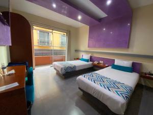 Habitación de hotel con 2 camas y ventana en Orizaba Inn en Orizaba