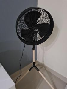 a black fan sitting on a stand in a room at Modern Executive Unit in East London