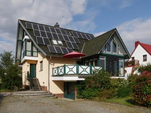 une maison avec des panneaux solaires sur le toit dans l'établissement Top Ferienwohnung im Herzen Reriks mit Garten, à Rerik