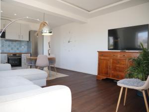 uma sala de estar com uma televisão e uma sala de jantar em Cozy Apartment With Sea View Over Meia Praia Lagos em Lagos