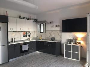 a kitchen with white cabinets and black appliances at Loukas House 2 Κέρκυρα Σταυρός Μακράτα in Stavrós