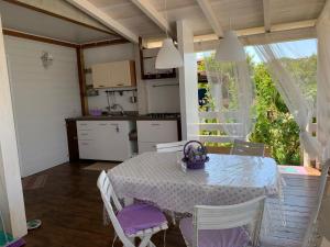 una cucina e una sala da pranzo con tavolo e sedie di Appartamento Cottage Lilla a 150 mt dal mare a Borgo Sabotino