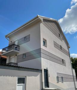 a white building with balconies on the side of it at Apartmani Gacic- Sabac in Šabac