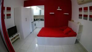 Habitación pequeña con cama roja y blanca. en Delta Sharm Holiday en Sharm El Sheikh