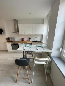 cocina con mesa, 2 sillas y fregadero en Le cottages des remparts - le lodge, en Boulogne-sur-Mer