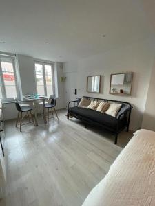 - une chambre avec un lit, une table et des chaises dans l'établissement Le cottages des remparts - le lodge, à Boulogne-sur-Mer