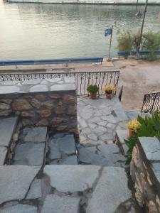 a stone walkway next to a body of water at Ilio Socrates in Skala Marion