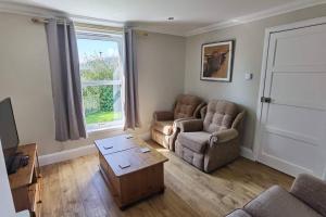 a living room with a couch and chairs and a table at Trotternish Avenue Staffin IV51 9JU in Staffin