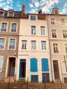 ein altes Gebäude mit blauen Türen und Fenstern in der Unterkunft Le cottages des remparts - le lodge in Boulogne-sur-Mer