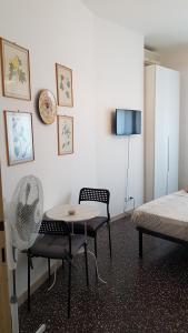 Habitación con mesa, sillas y TV. en B&B Diana, en Bolonia