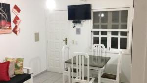 uma sala de jantar com uma mesa e 2 cadeiras brancas em Ape lindo em Porto - Oxente reserve logo em Porto Seguro
