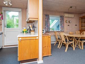 een keuken en eetkamer met een tafel en stoelen bij 6 person holiday home in Oksb l in Oksbøl