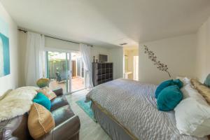 a bedroom with a bed and a couch at Beachwalk Villas in Carlsbad