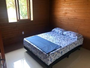 a small bed in a room with a window at Casa em Ibiraquera próxima a praia do Rosa in Imbituba