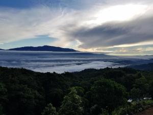 a view of a valley of clouds in the mountains at Escapadita al Bosque in San Isidro