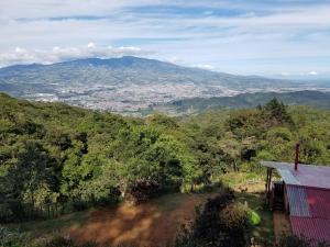 - une vue sur la montagne et une maison rouge dans l'établissement Escapadita al Bosque, à San Isidro