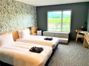 a hotel room with two beds and a window at Miru Niseko in Niseko