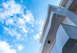 ein weißes Gebäude mit dem Himmel im Hintergrund in der Unterkunft W3 HOSTEL in Luodong