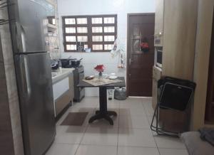 una cucina con tavolo al centro di Casa da San a Mongaguá