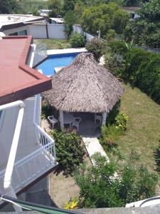 een resort met een zwembad en een rieten dak bij Villa kosniin in Tecolutla