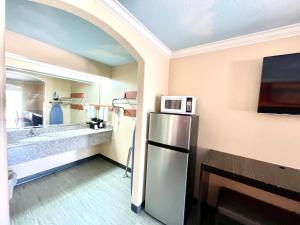 a kitchen with a refrigerator and a microwave on the wall at Luxury Inn Liberty in Liberty