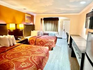 a hotel room with two beds and a bathroom at Luxury Inn Liberty in Liberty