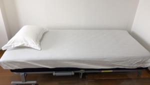 a bed with a white pillow on top of it at Guest house ORCA in Misato