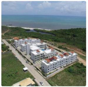 an aerial view of white buildings near the ocean at Residencial Granito e Jasmim Flat em Jacumã vista para o Mar in João Pessoa
