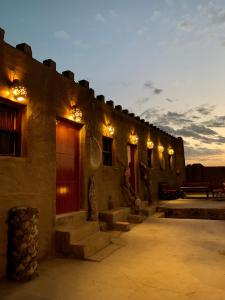 a building with lights on the side of it at Canyon Rest House Jabal Shams in Al Ḩamrāʼ
