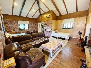 een woonkamer met een bank en een bed bij Red brick 642 B&B in Puli