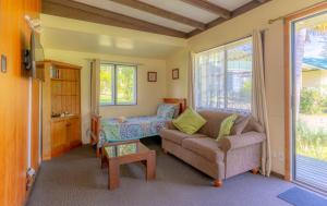 - un salon avec un canapé et une table dans l'établissement Anson Bay Lodge, à Burnt Pine