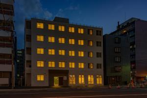 um edifício com as luzes acesas numa cidade em plat hostel keikyu sapporo sky em Sapporo