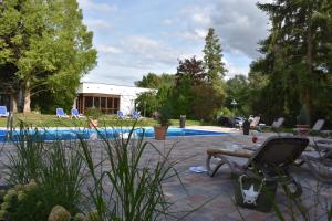 un patio con una silla y una piscina en Aqualux Wellness- & Tagungshotel, en Bad Salzschlirf