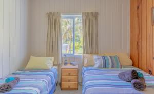 1 dormitorio con 2 camas y ventana en Anson Bay Lodge, en Burnt Pine