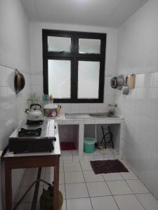 a kitchen with a stove and a window in it at KEY HOMESTAY in Pasakon 1