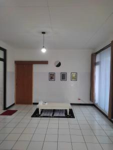 Zimmer mit weißem Fliesenboden und einem Tisch in der Unterkunft KEY HOMESTAY in Pasakon 1