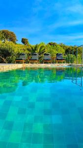 - une piscine avec deux chaises longues sur le côté du complexe dans l'établissement VILLA CORSA**** PISCINE VUE MER PANORAMIQUE, à Santa-Reparata-di-Balagna