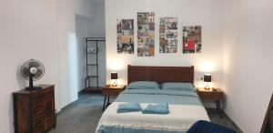 a bedroom with a bed with blue pillows and posters on the wall at Apartamentos Leman in Benicarló