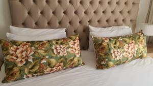two pillows on a bed with a padded headboard at Lush Living The Blyde Riverwalk Estate Unit 101 in Pretoria