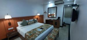 a hotel room with a large bed and a mirror at Hotel TSG Grand in Port Blair