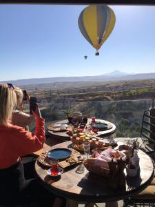a group of people taking pictures of a hot air balloon at Wish Cappadocia in Uçhisar