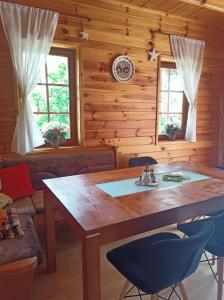 a dining room with a wooden table and chairs at Chata Xa-Inu in Sedliště