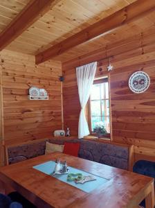 a dining room in a log cabin with a wooden table at Chata Xa-Inu in Sedliště