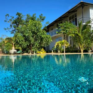 una piscina di fronte a un edificio di Sapphire Garden Hotel a Habarana