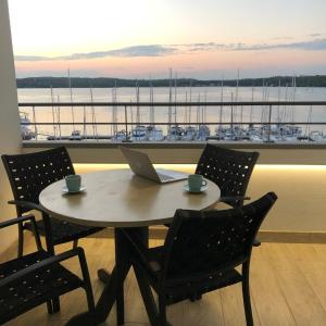 a table with a laptop on top of a room with a boat at Pula Center Seaview Apartment in Pula