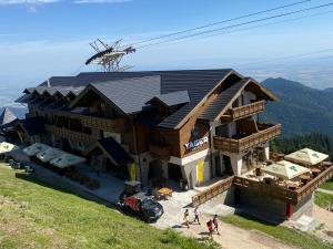 a building on top of a mountain with people standing around it at Yager Chalet in Poiana Brasov