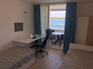a hotel room with a bed and a desk with a window at Pula Center Seaview Apartment in Pula