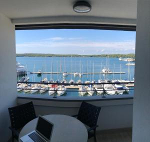 a window with a view of a marina with boats at Pula Center Seaview Apartment in Pula