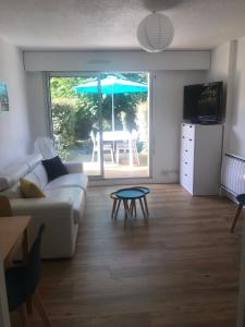 uma sala de estar com um sofá e uma mesa em Studio Les Pétrels avec terrasse et jardinet à 2 pas de la plage em Pornichet