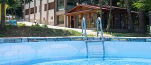 a swimming pool with a chair in front of a building at Бунгала Камена - Bungalows Kamena in Kamena